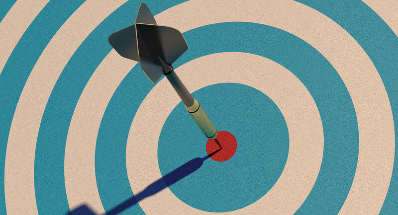 A dart hitting a red target at the center of a dart board 